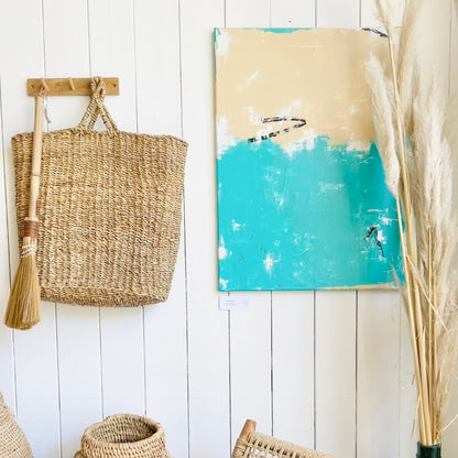 Abstraktes Kunstwerk von FLOR. in den Farben Türkis, Schwarz, Weiß und Beige hängend in einem Restaurant.